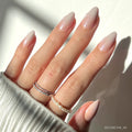 Fiancéd elegant press-on nails in soft nude shade showcasing almond shape and glossy finish on hand model